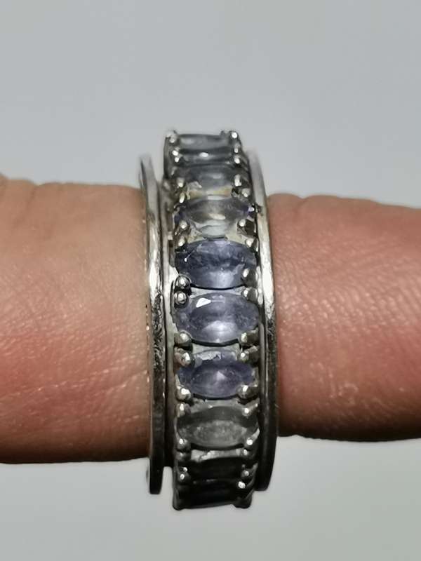 BEAUTIFUL SILVER MOVING RING WITH TANZANITE LIKE STONES AND HEART MOTIF. WEIGHT: 7.95 GRAMS.