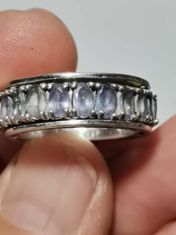 BEAUTIFUL SILVER MOVING RING WITH TANZANITE LIKE STONES AND HEART MOTIF. WEIGHT: 7.95 GRAMS.