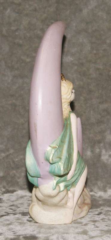 Ceramic fairy sitting on a moon statue