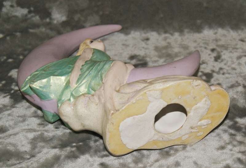 Ceramic fairy sitting on a moon statue