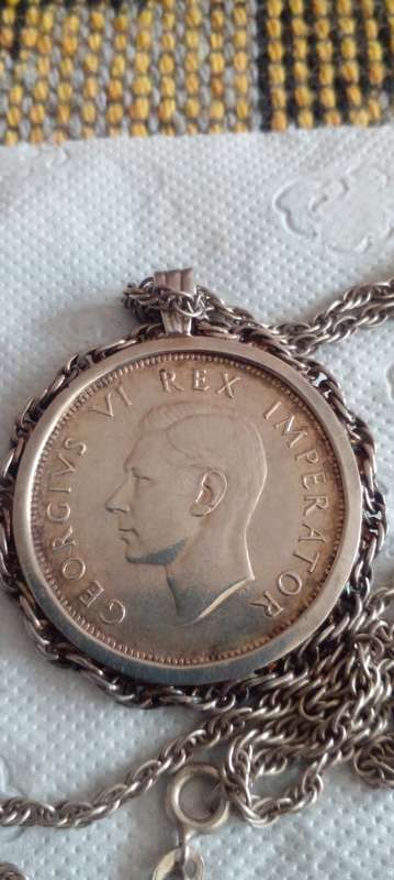 1938 SILVER UNION OF SA HALFCROWN , SET IN A SILVER SETTING AND A  58 CMS LONG SILVER CHAIN.  DESC.