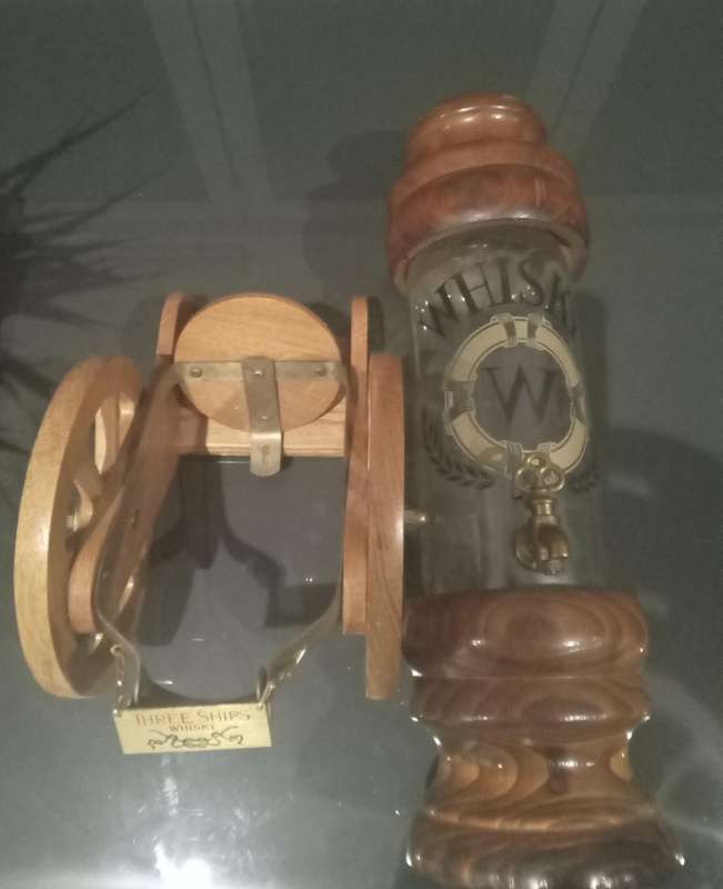 ANTIQUE WHISKEY DISPENSER AND THREE SHIPS WHISKEY BOTTLE CANON HOLDER