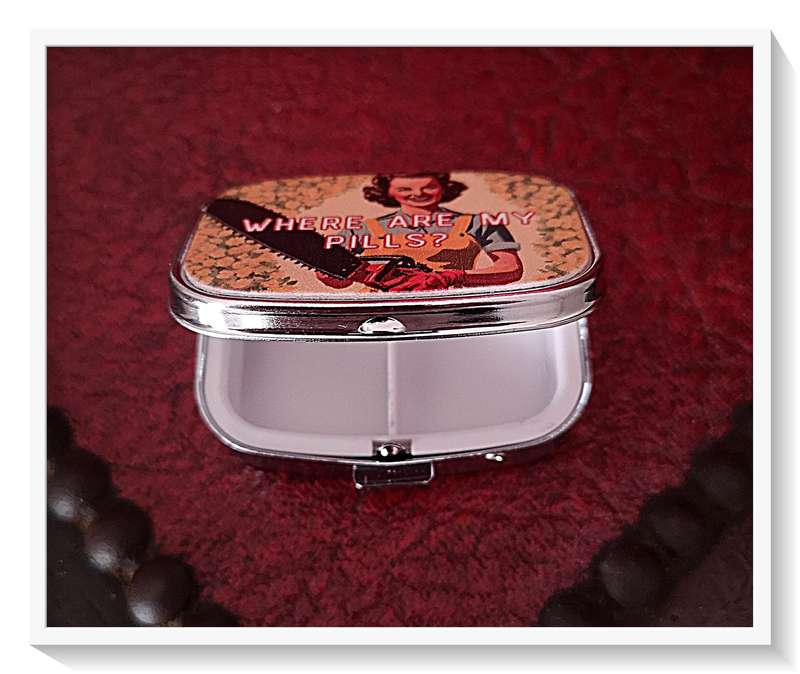 A Quirky Vintage Style Pill Box with a Chainsaw Wielding Lady on the Cover