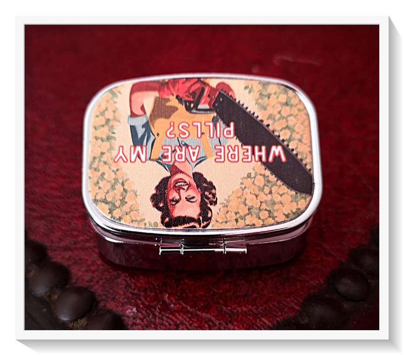 A Quirky Vintage Style Pill Box with a Chainsaw Wielding Lady on the Cover