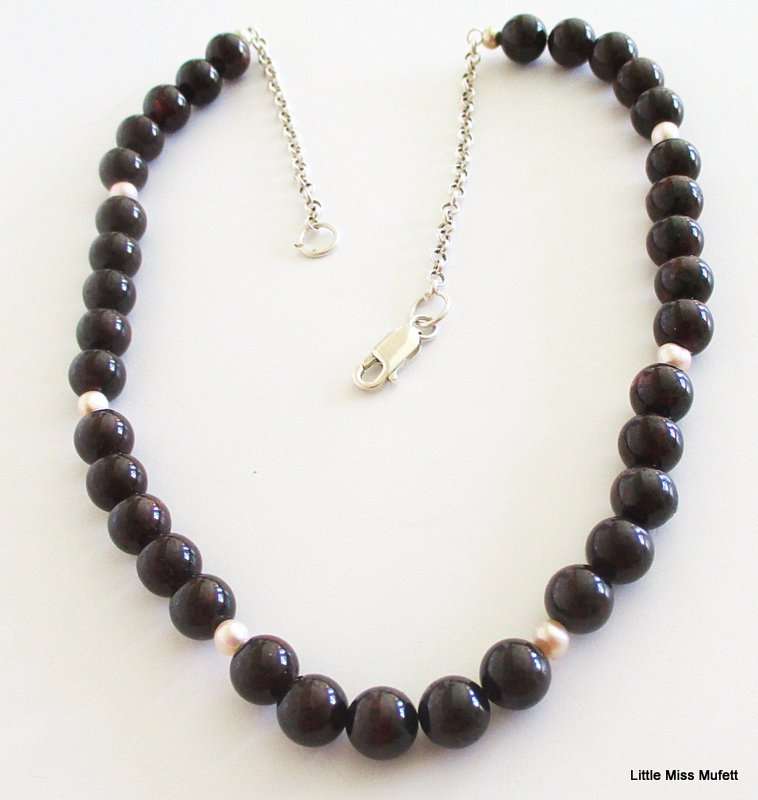 A Garnet and Pearl necklace on a sterling silver clasp and chain. 49cm adjustable to downsize
