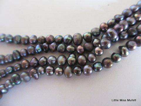 A BEAUTIFULLY TONED FRESH WATER PEARL 3 STRING BRACELET WITH A LARGE MOTHER OF PEARL CLASP