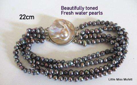 A BEAUTIFULLY TONED FRESH WATER PEARL 3 STRING BRACELET WITH A LARGE MOTHER OF PEARL CLASP