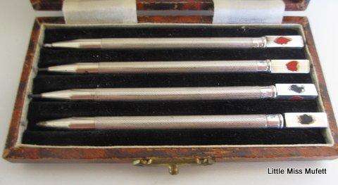 A delightful box of sterling silver bridge pencils