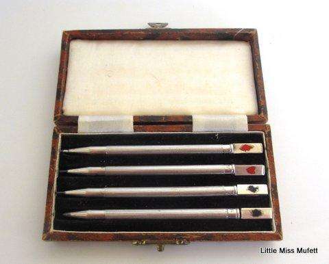 A delightful box of sterling silver bridge pencils