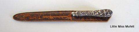 A Letter opener with a sterling silver handle in a leather cover.--Please read description