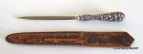 A Letter opener with a sterling silver handle in a leather cover.--Please read description