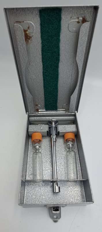 Boots viule syringe in a metal case with two glass containers with needles inside.