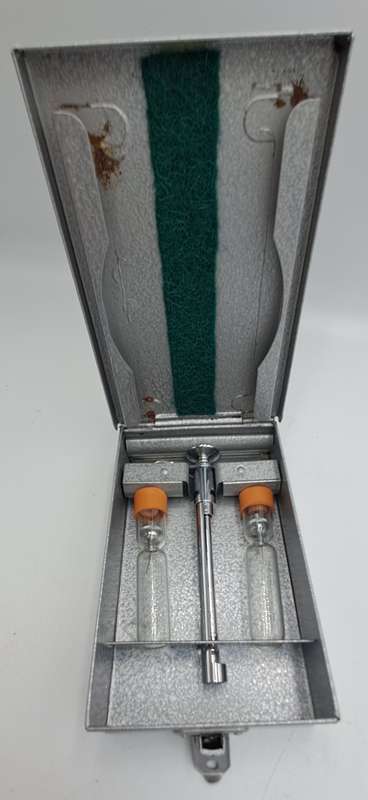 Boots viule syringe in a metal case with two glass containers with needles inside.