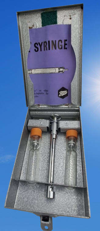 Boots viule syringe in a metal case with two glass containers with needles inside.