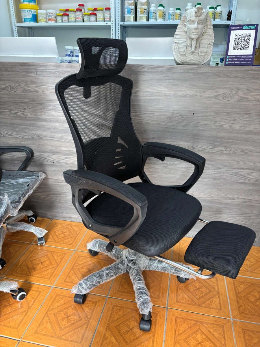 Office chair with high-back reclining backrest, headrest, and footrest. Black frame