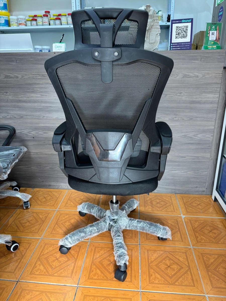Office chair with high-back reclining backrest, headrest, and footrest. Black frame
