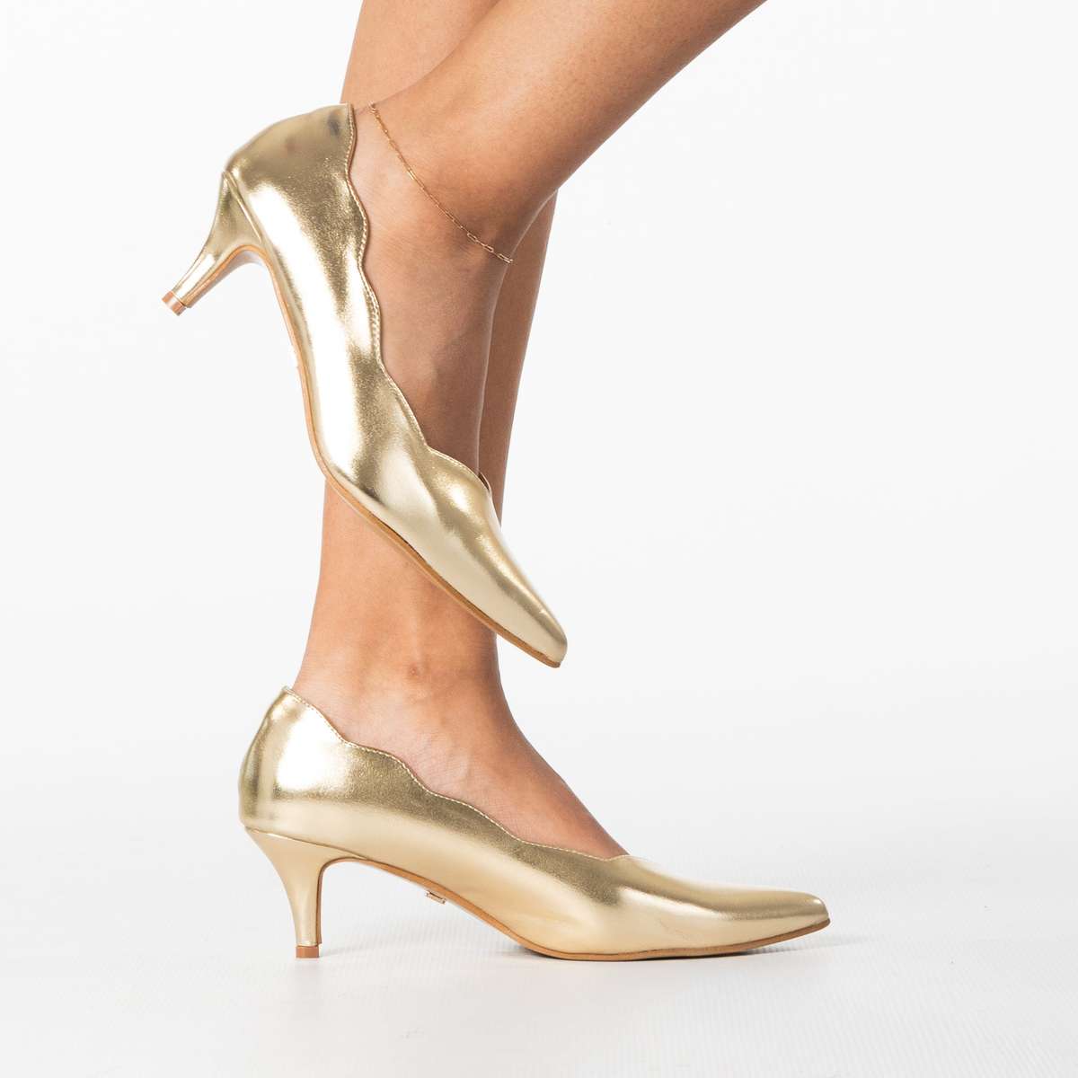 Enjoy women's sleek pointed heel with scalloped edge detail