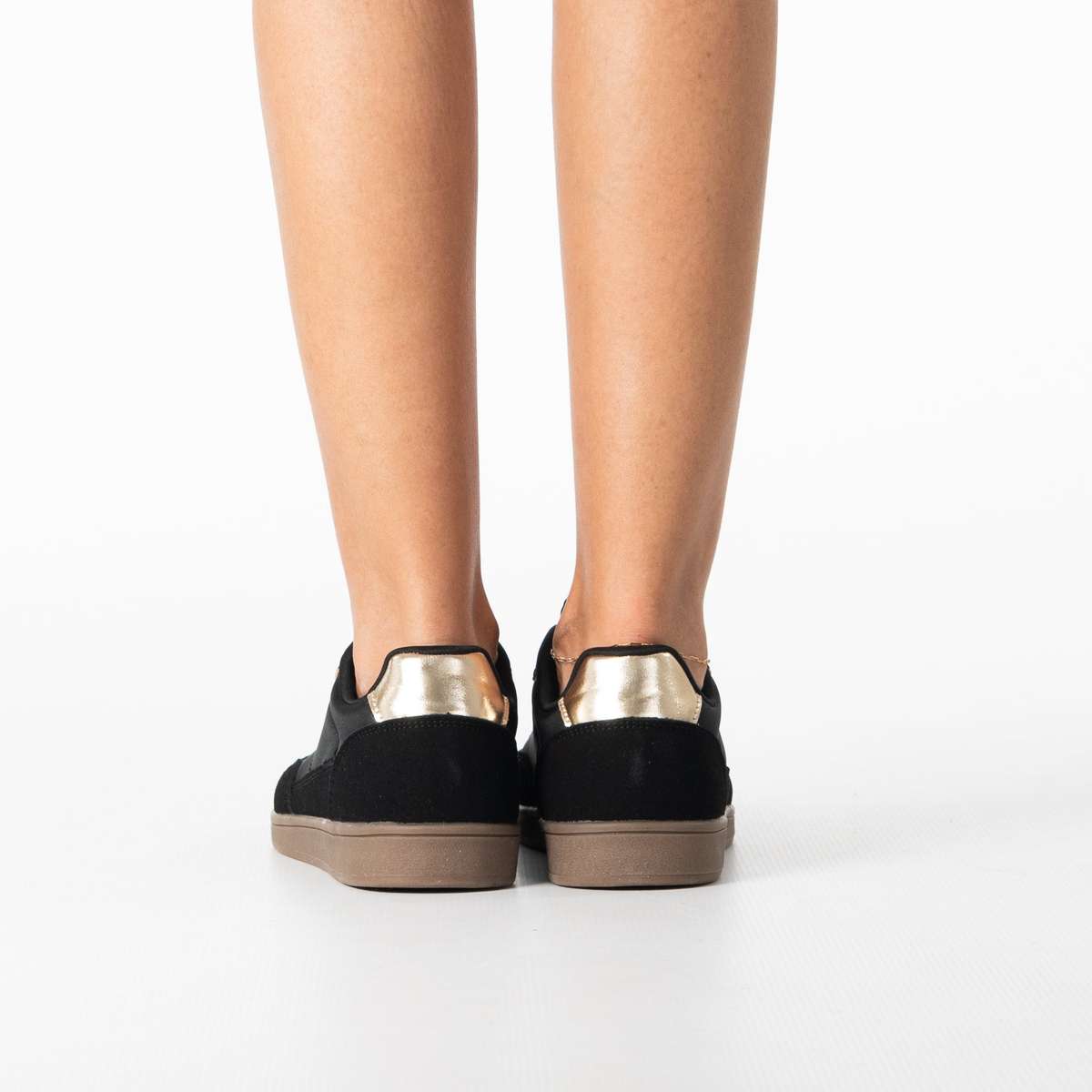 Uma women's sleek black sneaker with gold zip detail