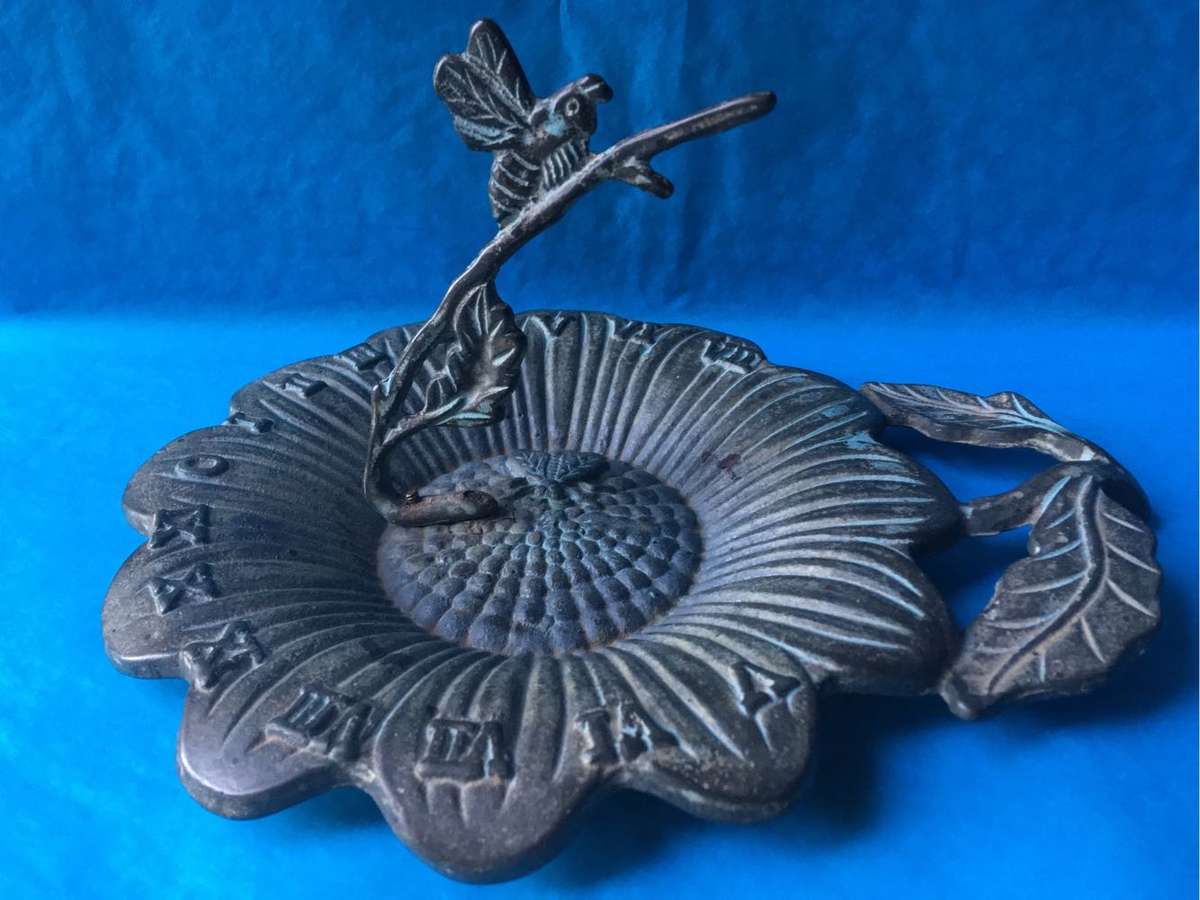 Vintage bronze sundial with dragonfly