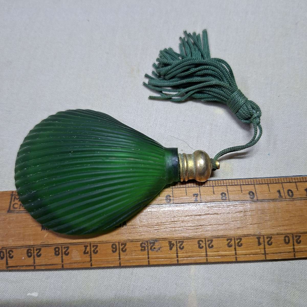 Green glass perfume bottle - shell shaped flat on one side.  7.5 x 5 cms