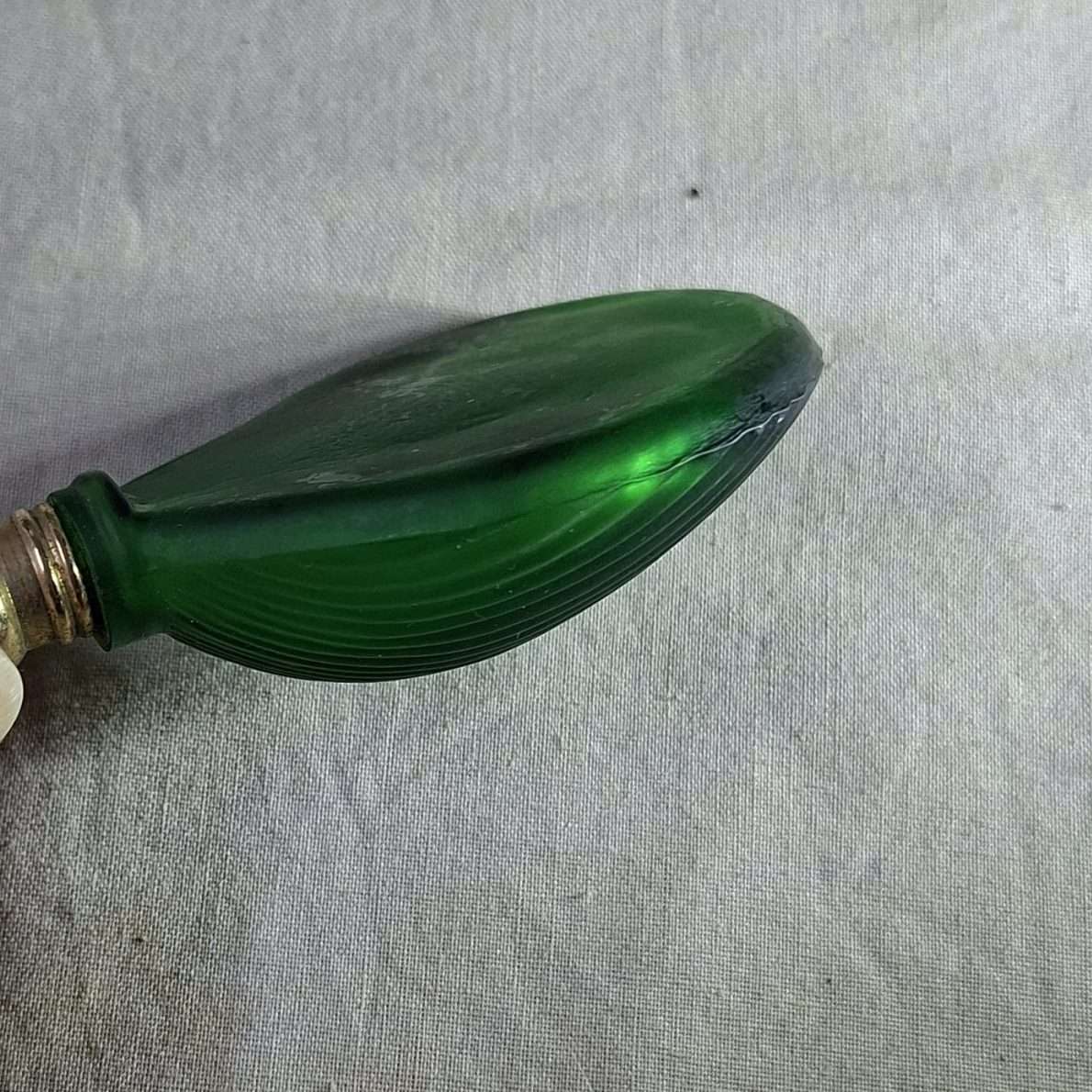 Green glass perfume bottle - shell shaped flat on one side.  7.5 x 5 cms