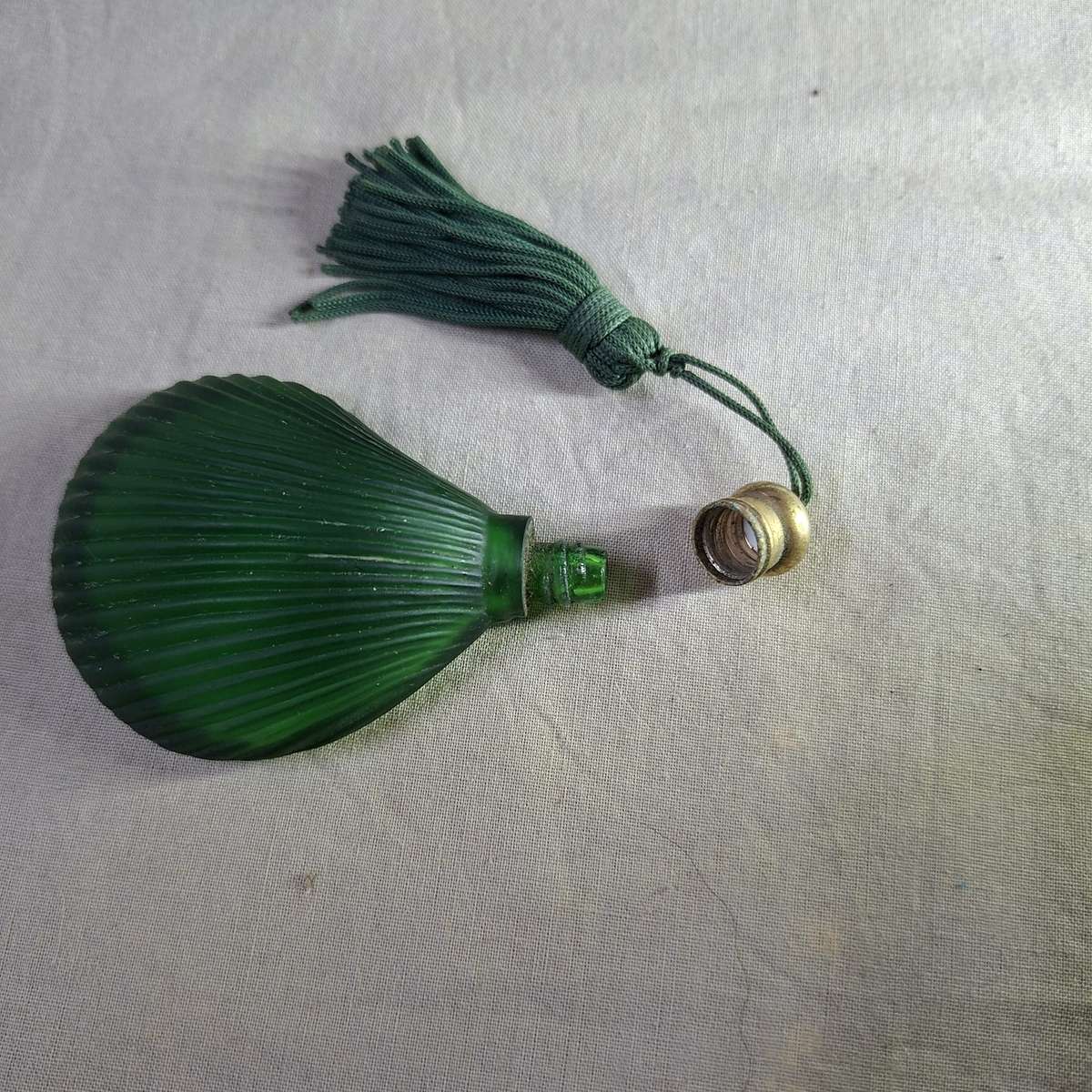 Green glass perfume bottle - shell shaped flat on one side.  7.5 x 5 cms
