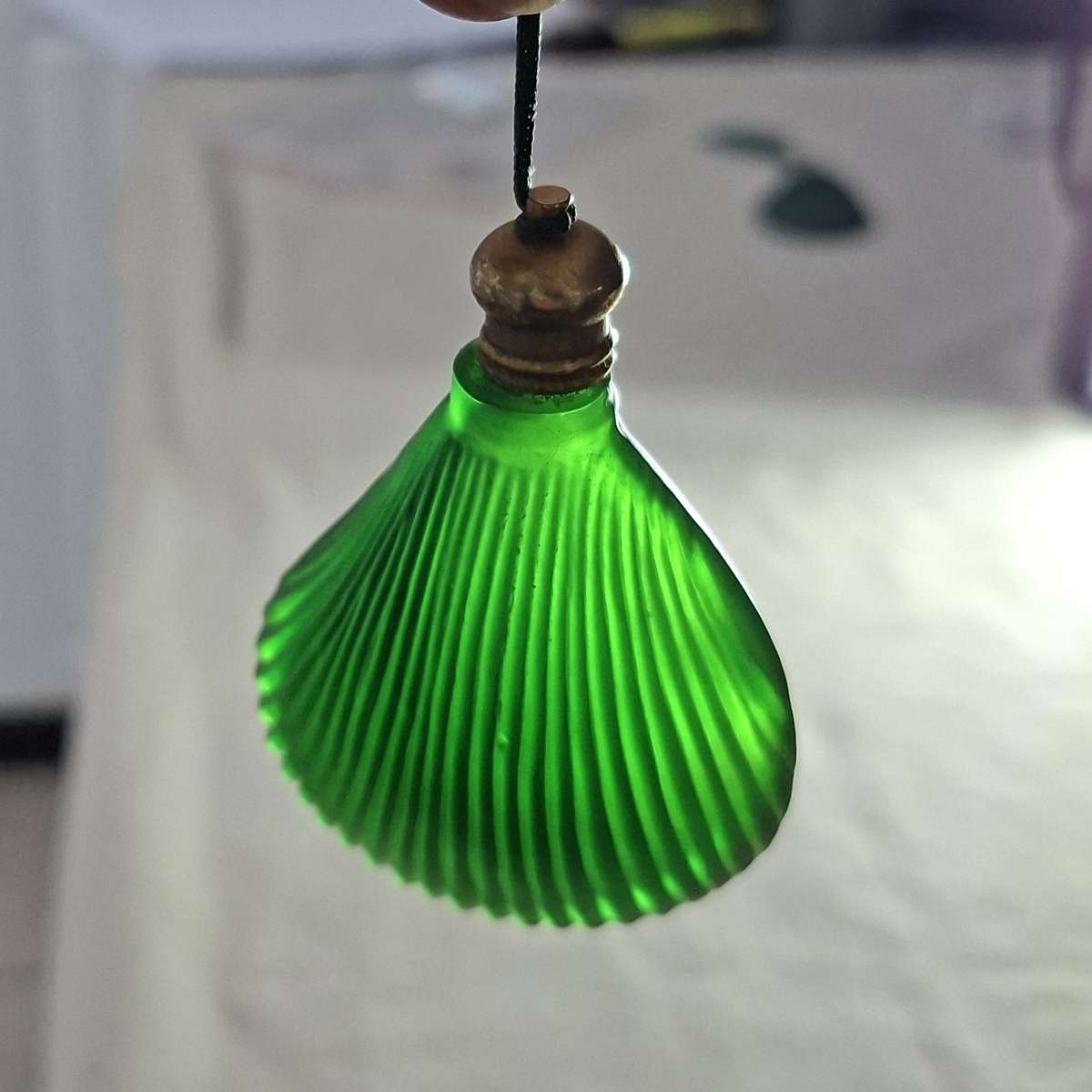 Green glass perfume bottle - shell shaped flat on one side.  7.5 x 5 cms