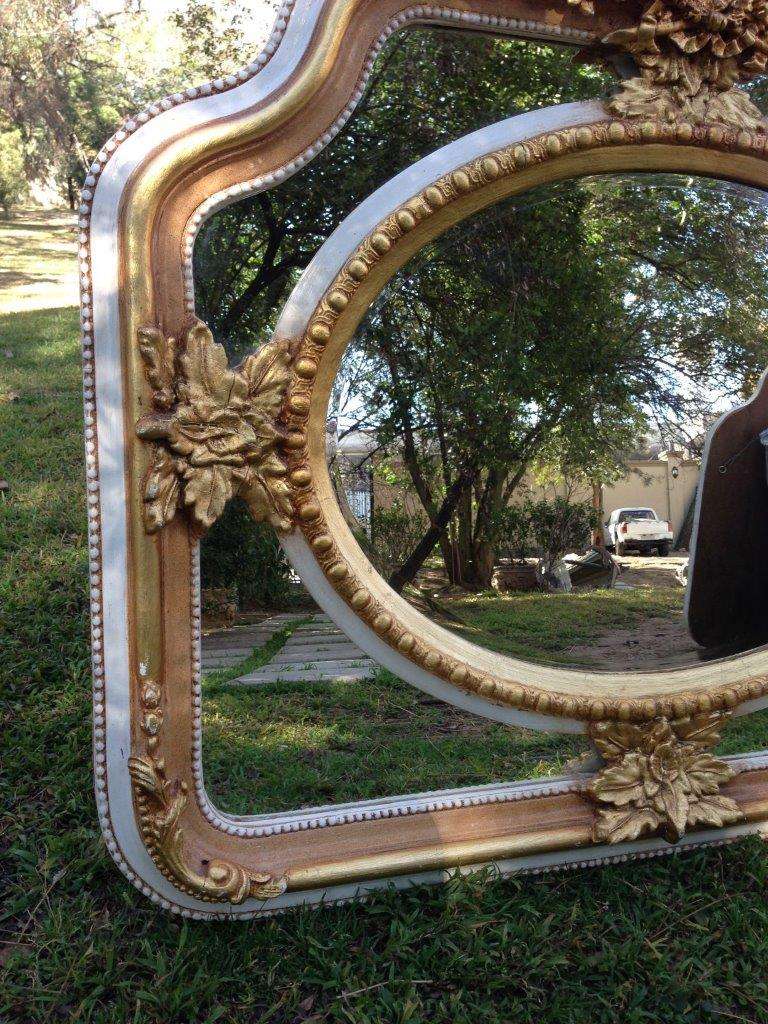 A French Ornate carved mirror with a bevelled oval centre section