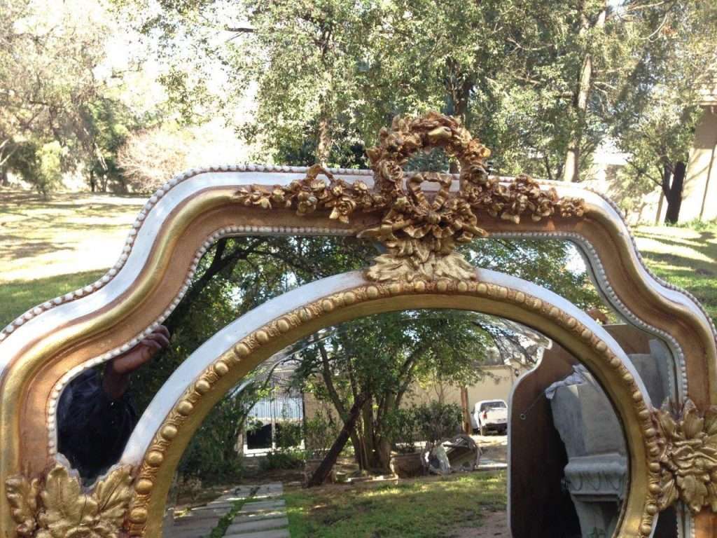 A French Ornate carved mirror with a bevelled oval centre section