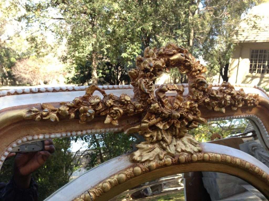 A French Ornate carved mirror with a bevelled oval centre section