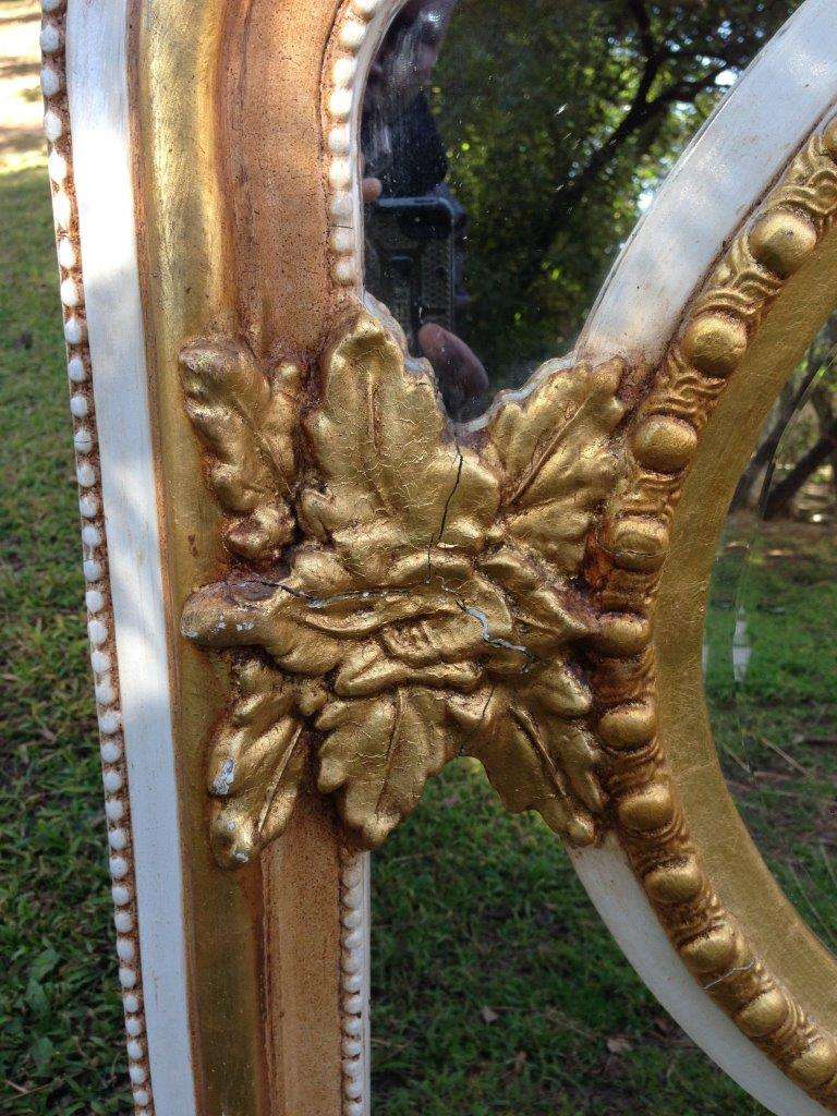 A French Ornate carved mirror with a bevelled oval centre section