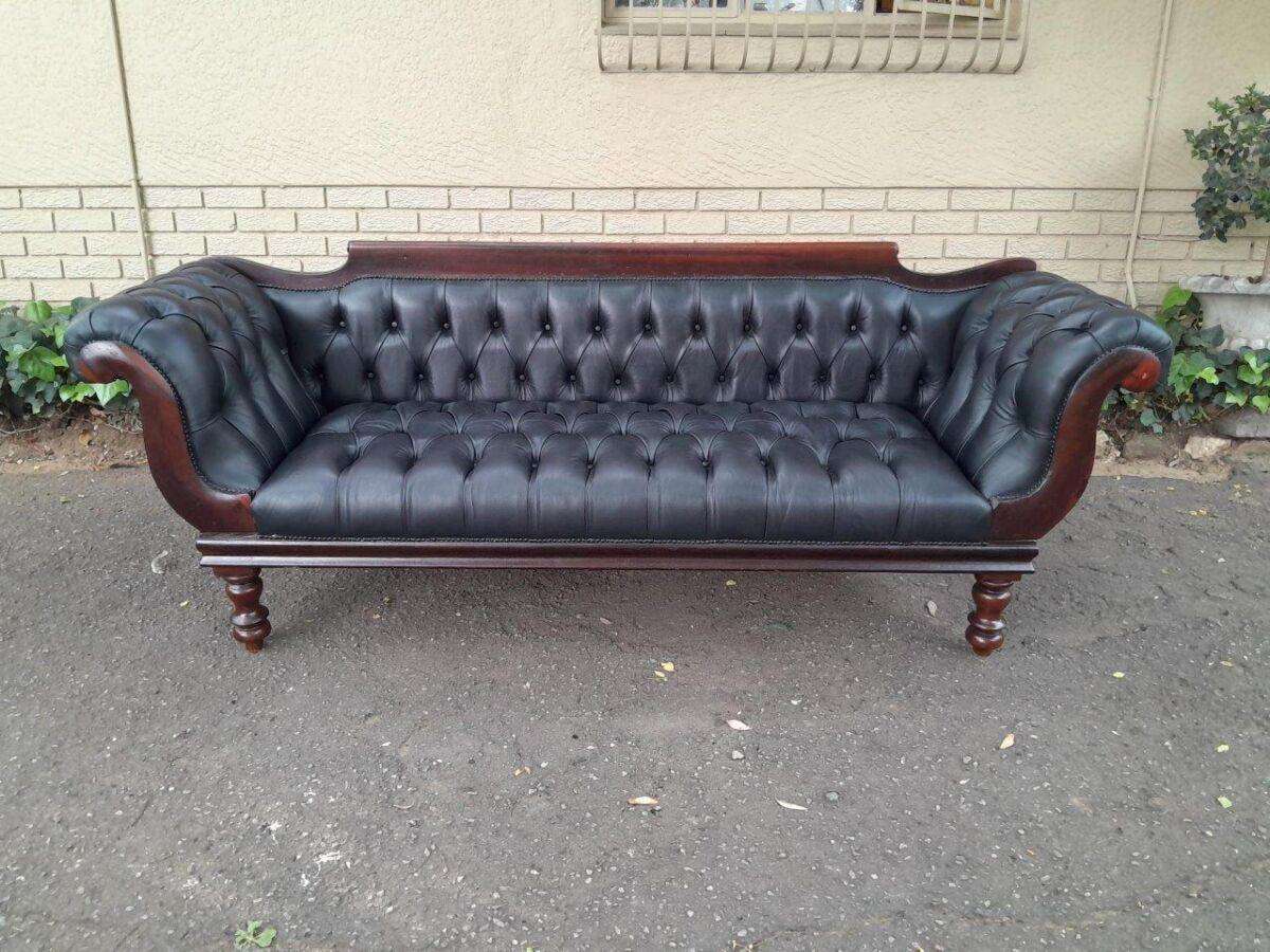 A 19th Century Regency Style Stinkwood Settee Upholstered In Deep Buttoned Leather