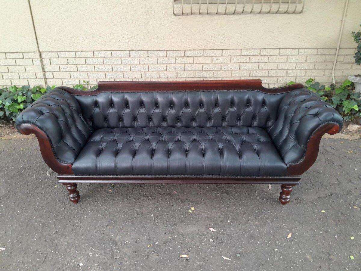 A 19th Century Regency Style Stinkwood Settee Upholstered In Deep Buttoned Leather