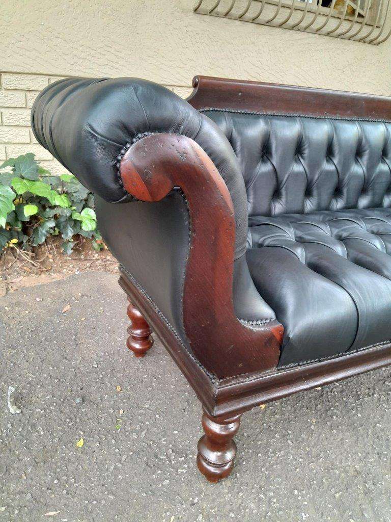 A 19th Century Regency Style Stinkwood Settee Upholstered In Deep Buttoned Leather