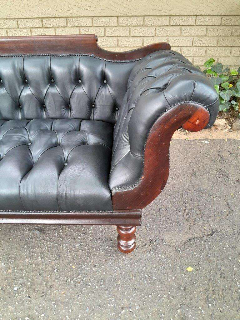 A 19th Century Regency Style Stinkwood Settee Upholstered In Deep Buttoned Leather