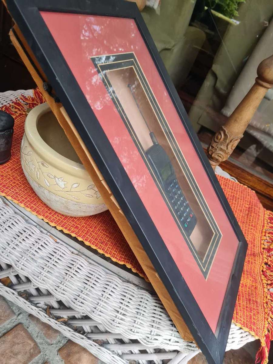 Orbitel cellphone mounted in glass fronted frame