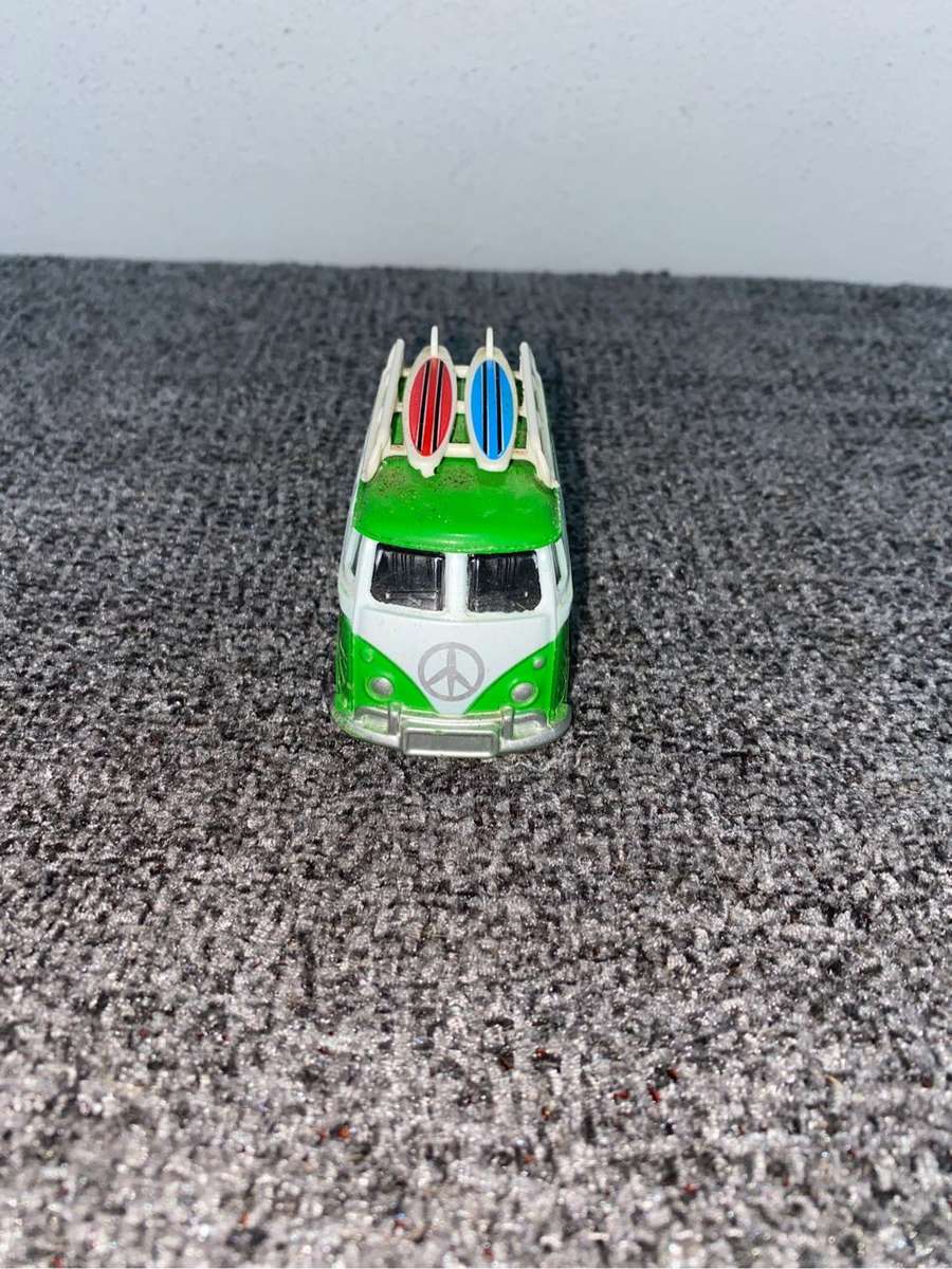 Green VW Minibus with a surfboard