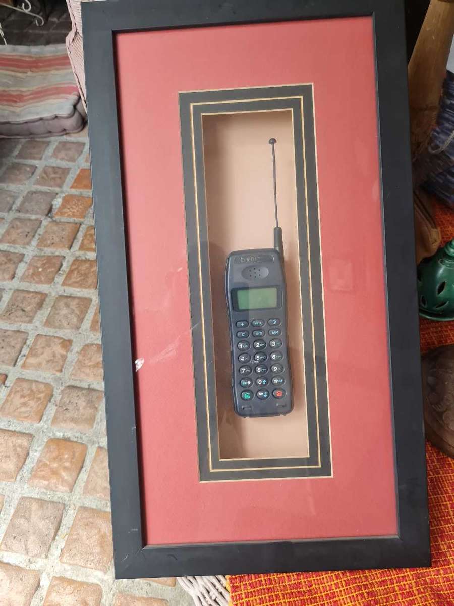 Orbitel cellphone mounted in glass fronted frame