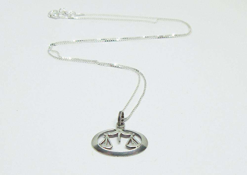 A vintage sterling silver Libra Zodiac sign pendant with a sterling silver necklace