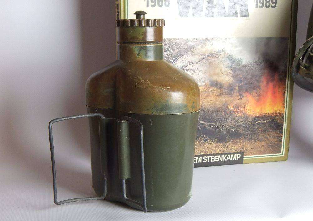 A vintage SA army helmet , water bottle and a book about the South African Border War