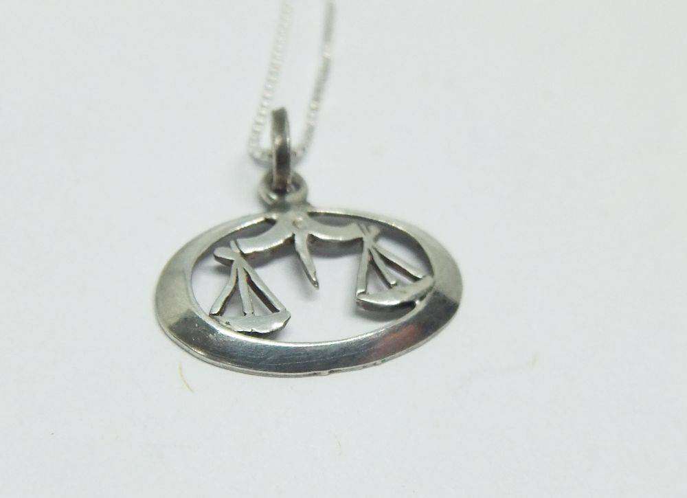 A vintage sterling silver Libra Zodiac sign pendant with a sterling silver necklace