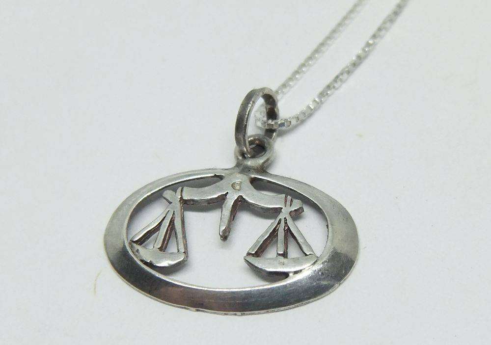 A vintage sterling silver Libra Zodiac sign pendant with a sterling silver necklace