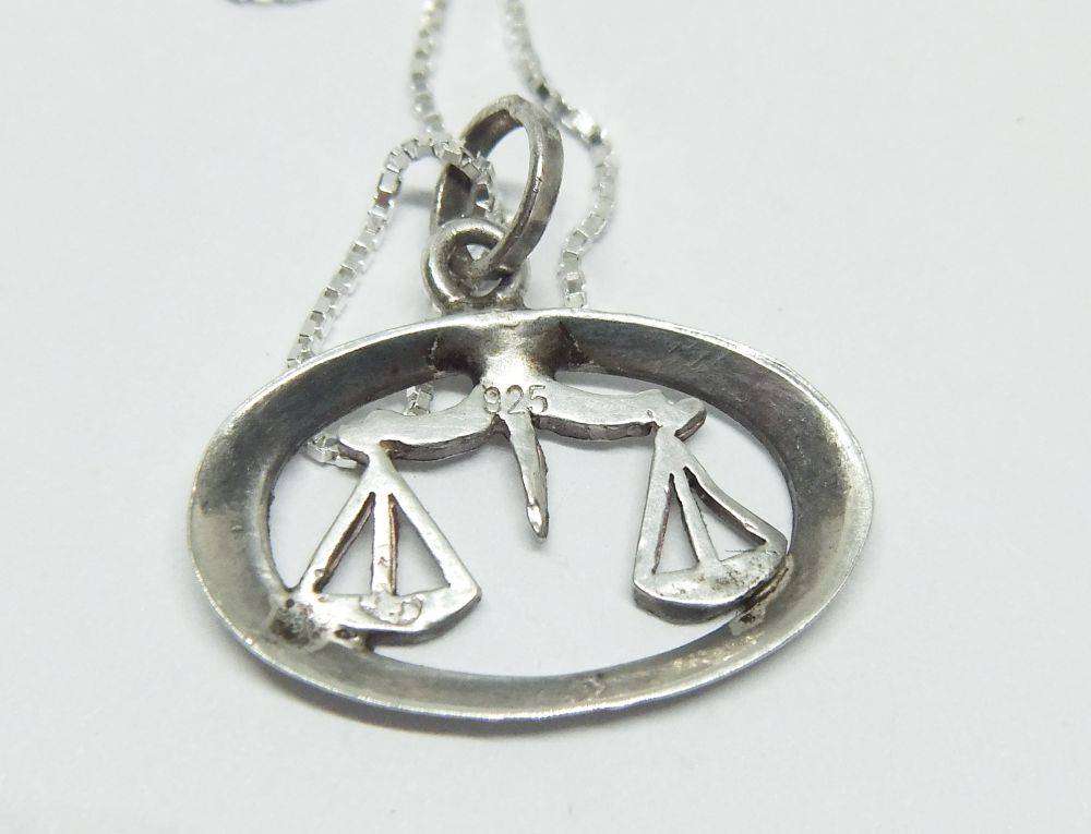 A vintage sterling silver Libra Zodiac sign pendant with a sterling silver necklace