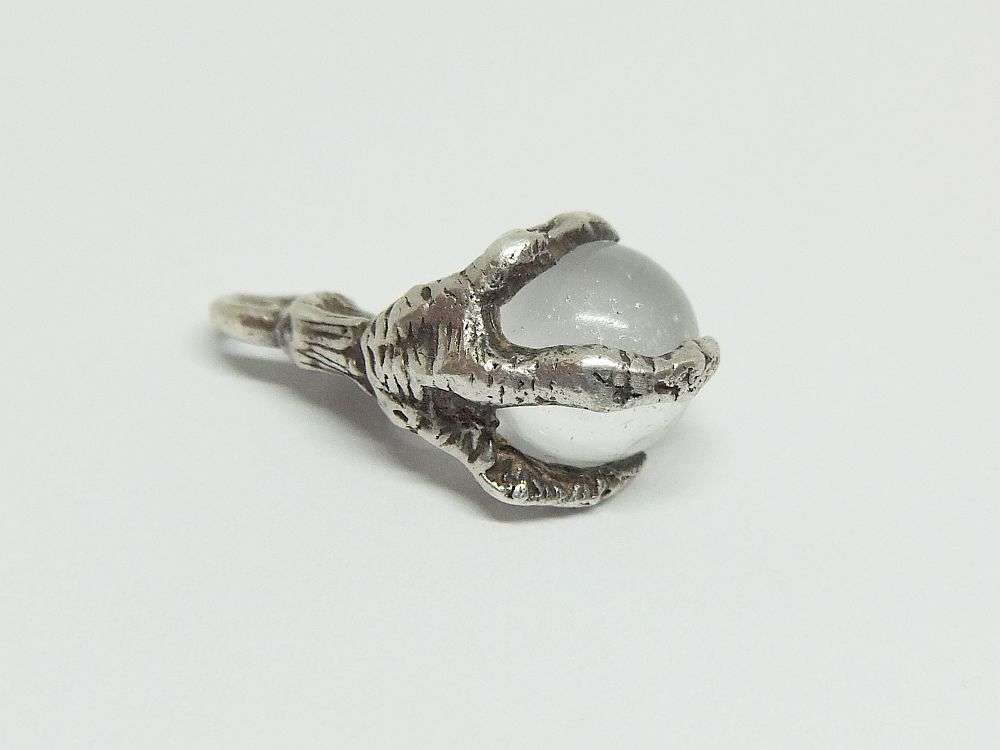 AN OLD LOOKING STERLING SILVER PENDANT OR CHARM MODELED AS AN EAGLES CLAW HOLDING A GLASS ORB !!