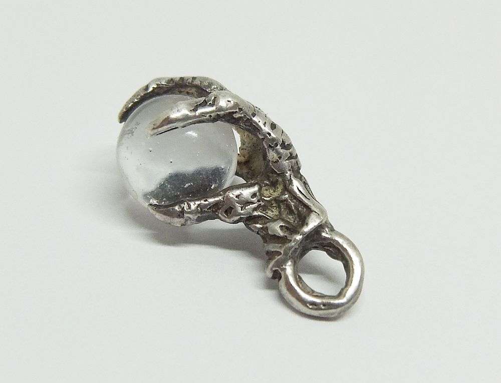 AN OLD LOOKING STERLING SILVER PENDANT OR CHARM MODELED AS AN EAGLES CLAW HOLDING A GLASS ORB !!