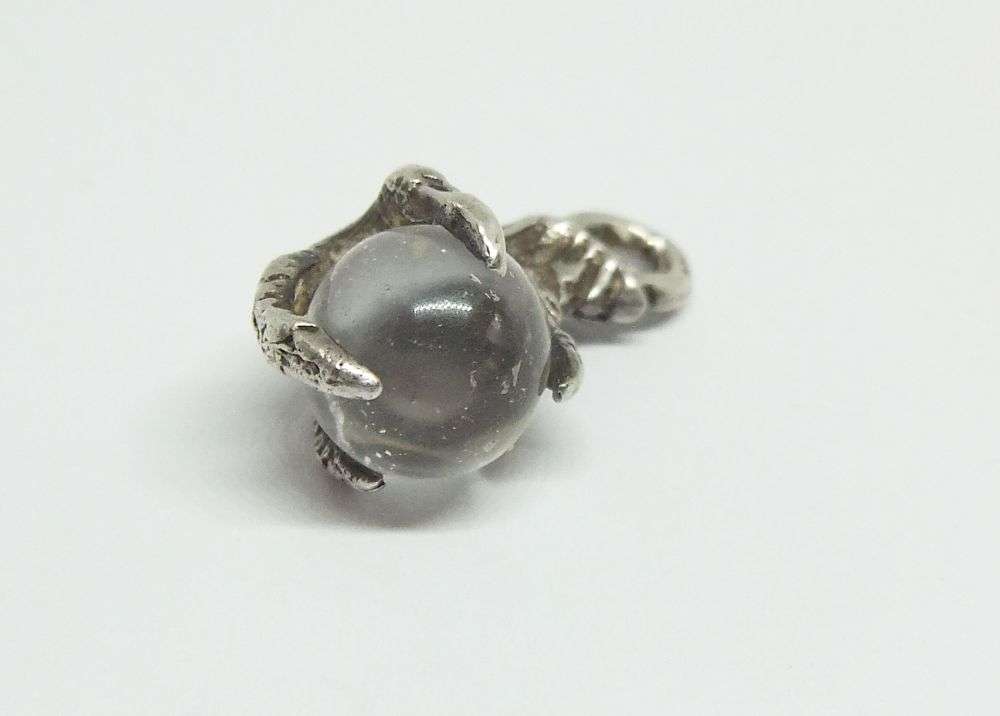 AN OLD LOOKING STERLING SILVER PENDANT OR CHARM MODELED AS AN EAGLES CLAW HOLDING A GLASS ORB !!