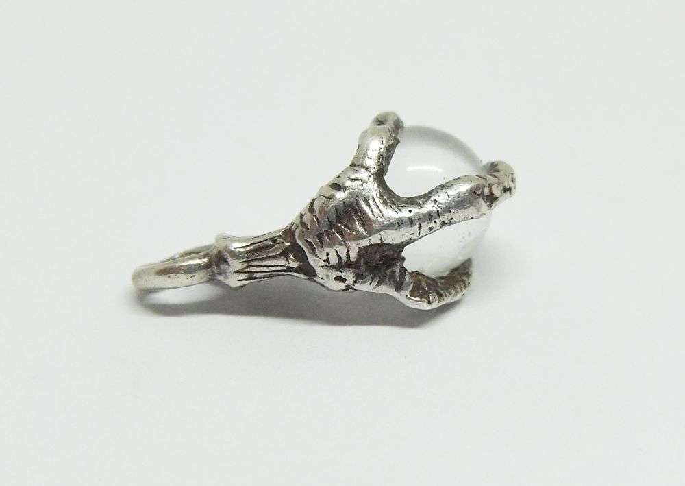 AN OLD LOOKING STERLING SILVER PENDANT OR CHARM MODELED AS AN EAGLES CLAW HOLDING A GLASS ORB !!