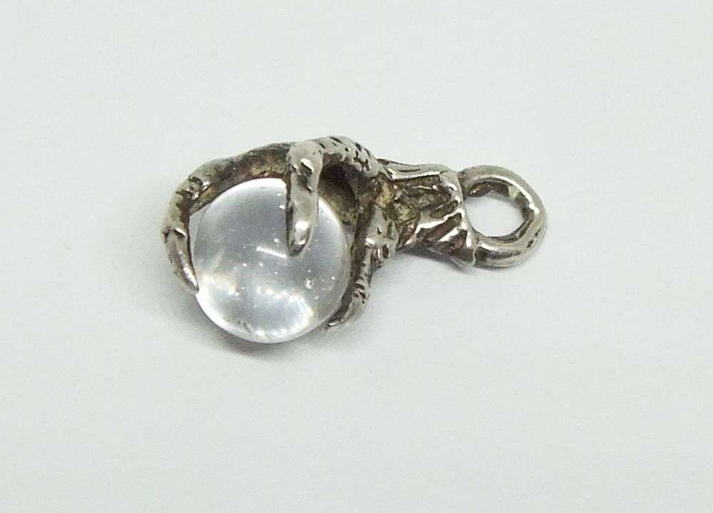 AN OLD LOOKING STERLING SILVER PENDANT OR CHARM MODELED AS AN EAGLES CLAW HOLDING A GLASS ORB !!