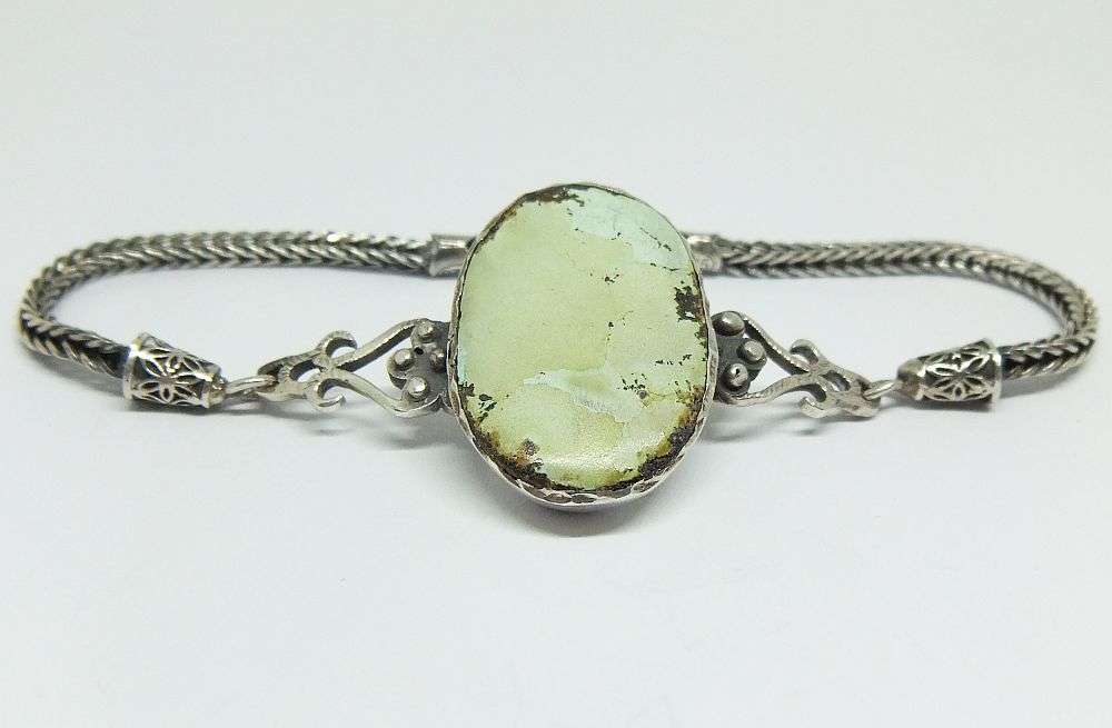 AN EYE CATCHING STERLING SILVER BRACELET SET WITH AN OVAL GREEN AGATE STONE - IMPORTED FROM TURKEY