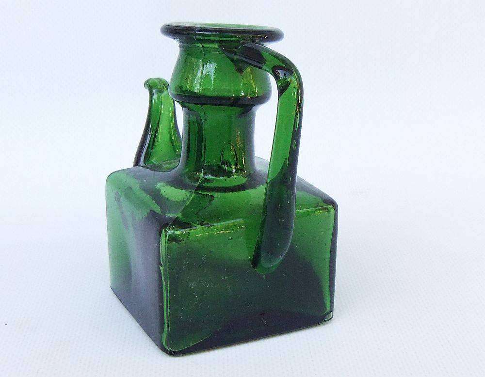 An interesting old green glass vessel